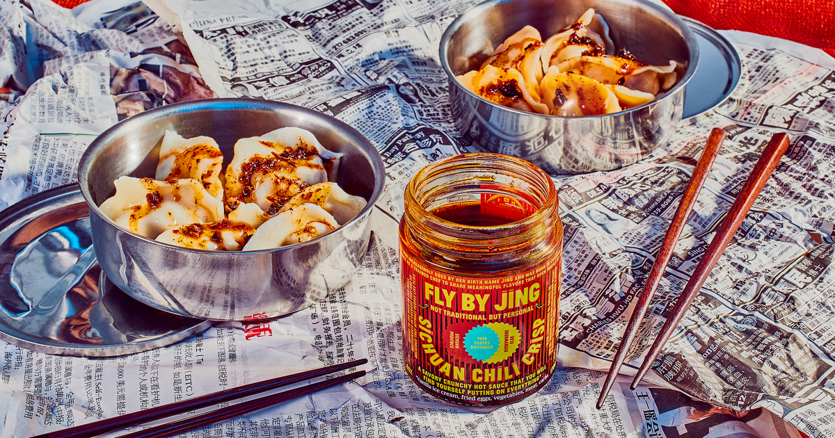 jar of chili crisp with two bowls of dumplings