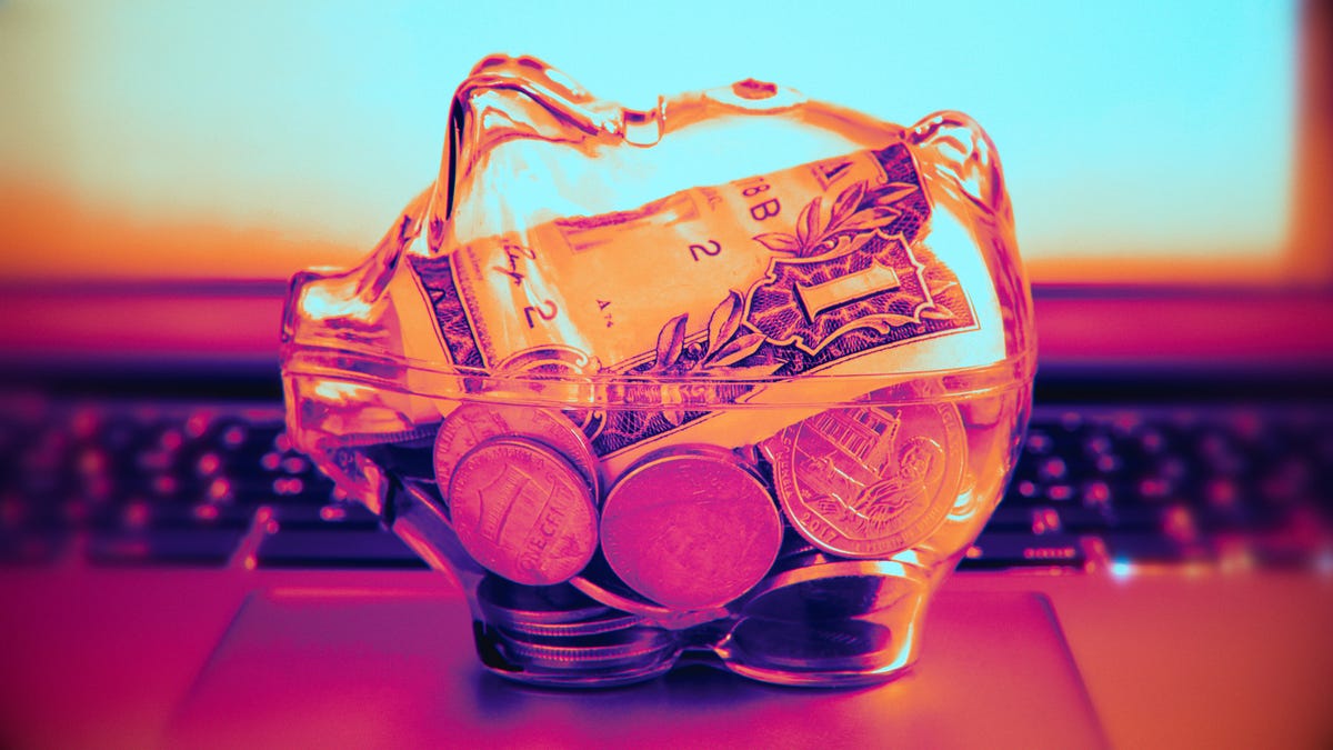 piggy bank with money on laptop