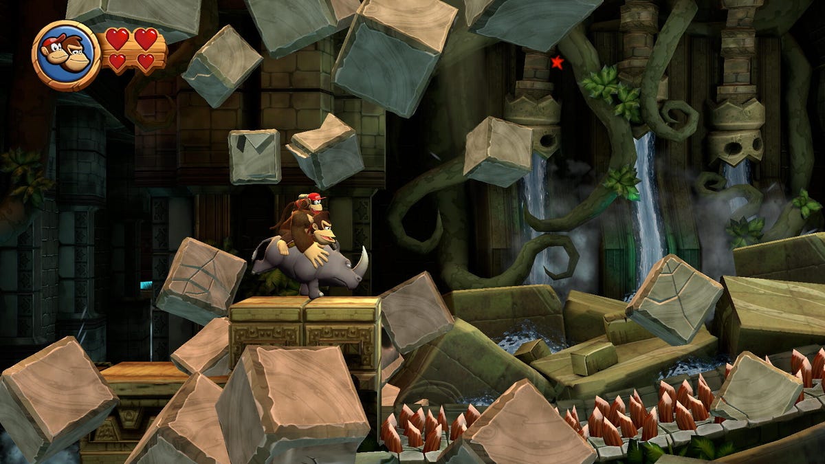 A screenshot of a video game by Nintendo, with Donkey Kong riding a rhinoceros in a cave