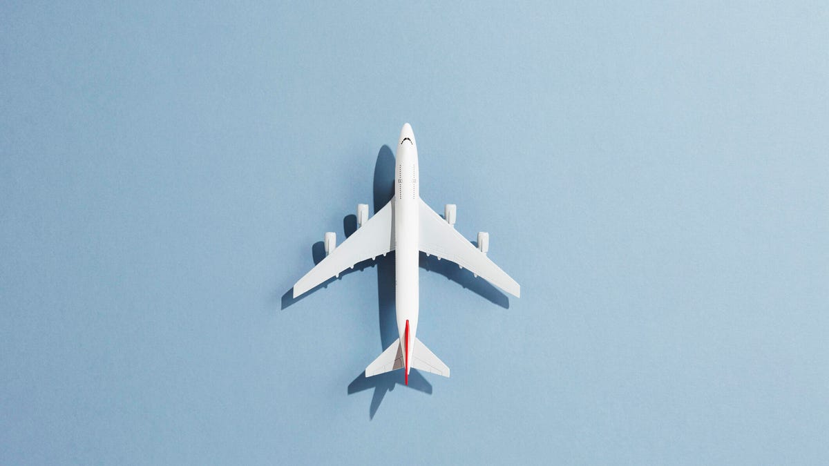 White model airplane with red stripe on a blue background