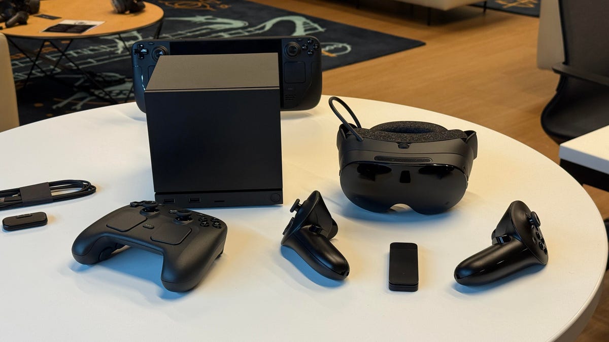 Valve's lineup of 2026 products in black: Steam Machine, Steam Controller, Steam Frame and Steam Deck in view on table