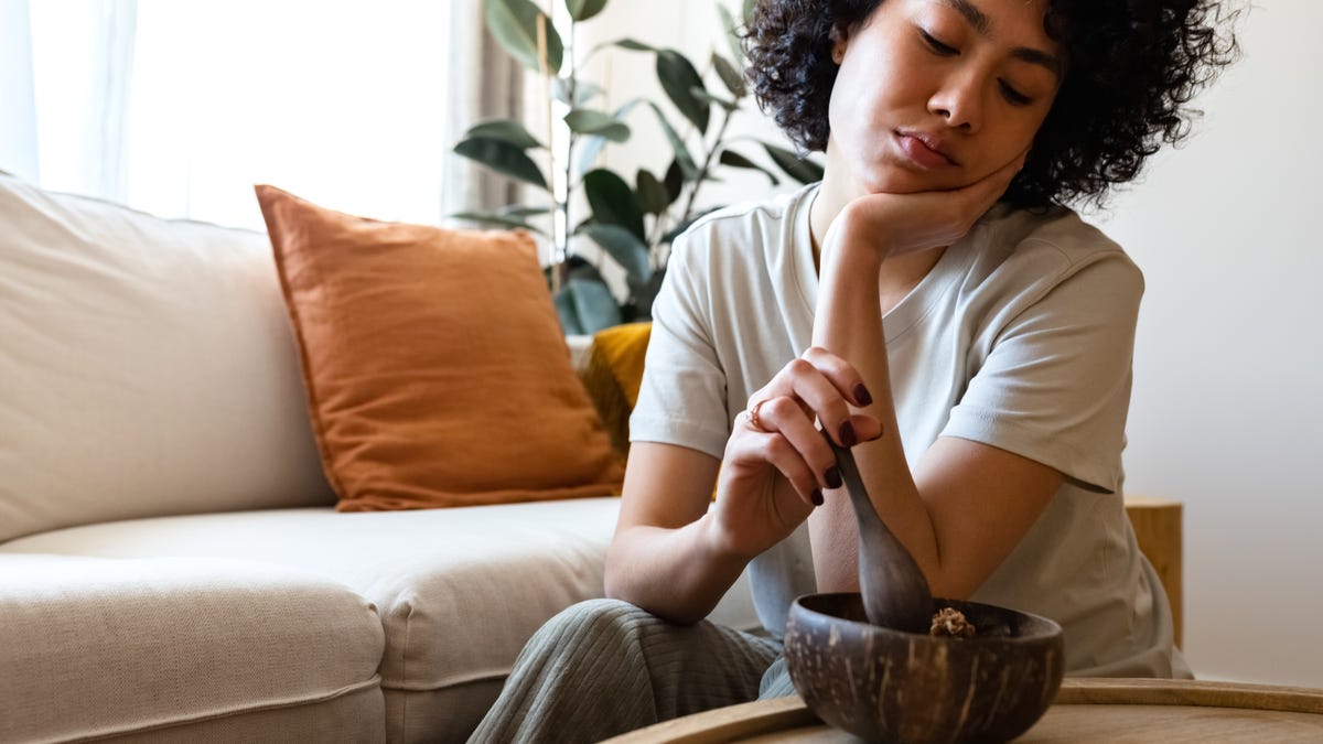 Tired woman with no appetite looking at her food