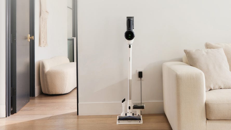 Tineco Pure One S15 Pet in its stand near a couch.