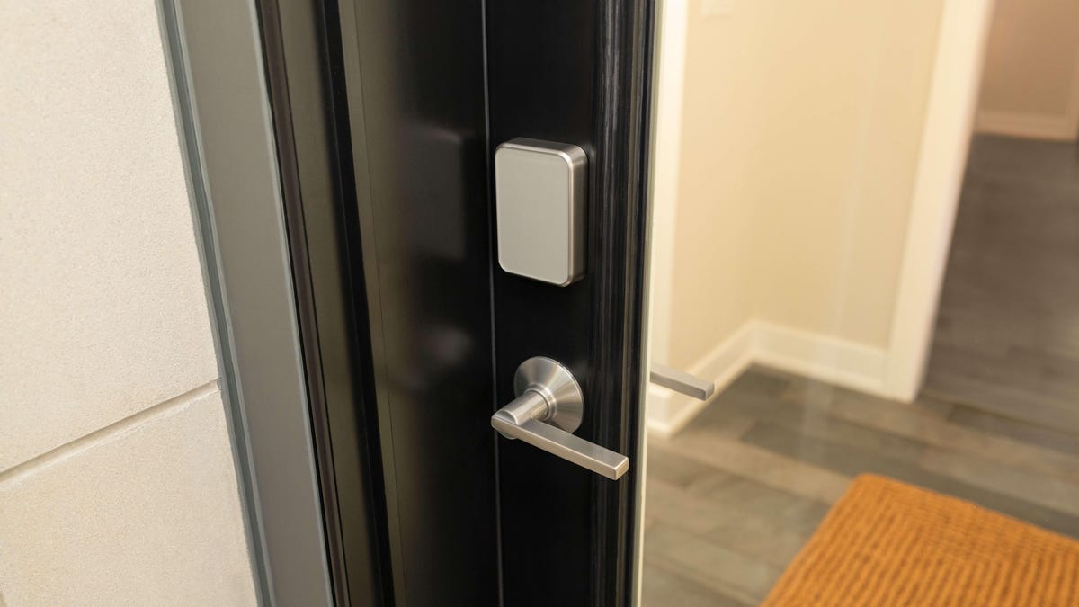 A silver Schlage lock in a brown glass door.