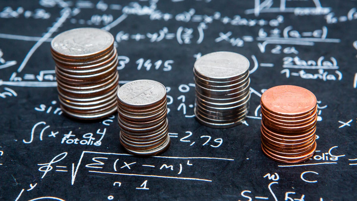 Stacks of coins on a slate with mathematical equations