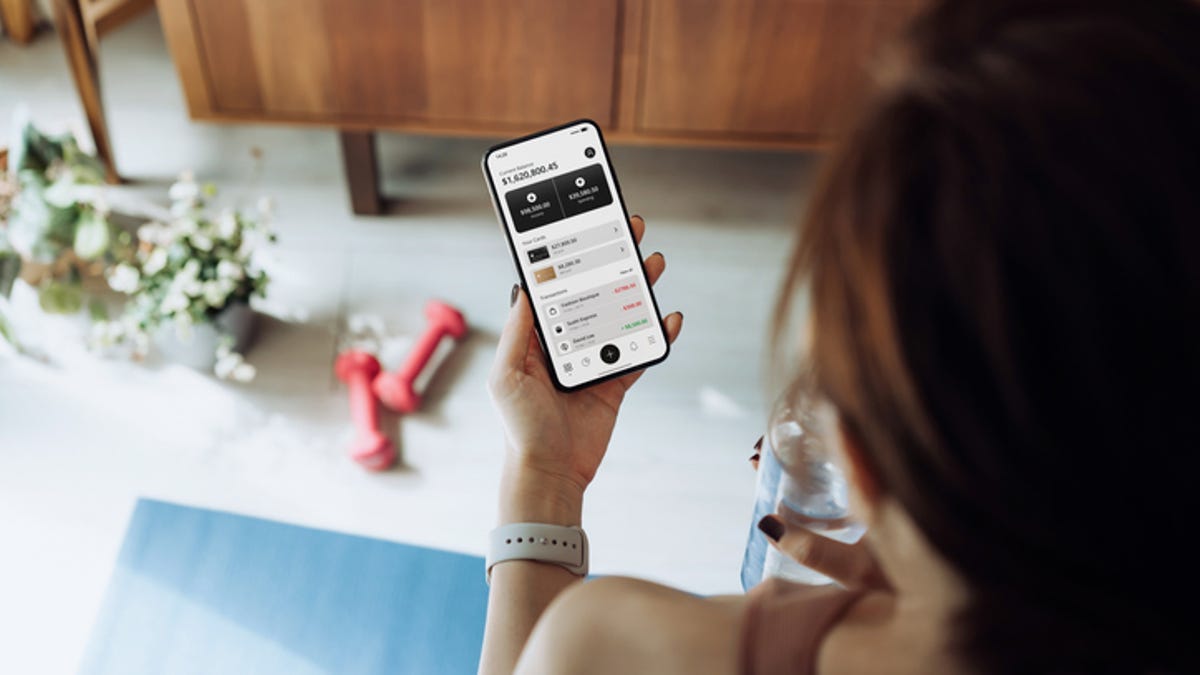 woman reading workout app on cell phone