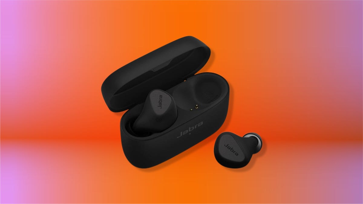 Titanium black Jabra Elite 5 earbuds with one ear outside the case on an orange gradient CNET background.