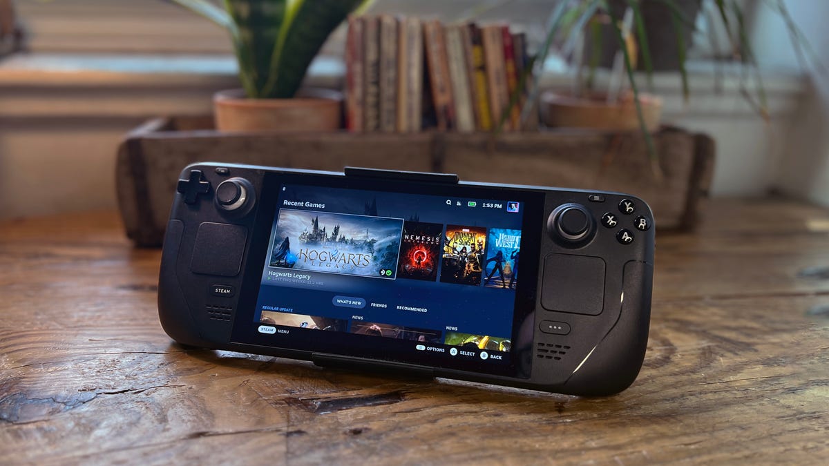 A Steam Deck with a kickstand on a wood desk.