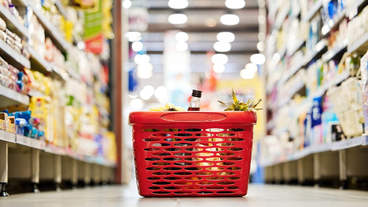 A red grocery basket with food in it