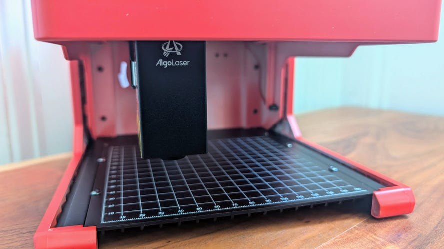 A little red laser engraver with the front open showing the 5 watt laser module