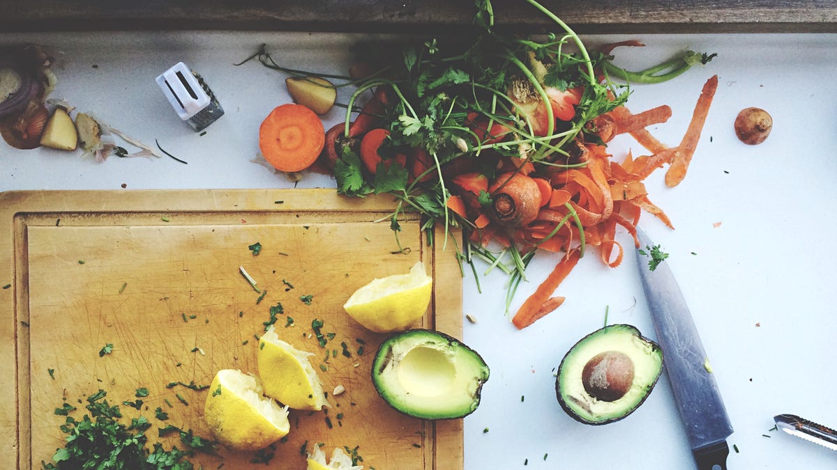 Cutting board with avocados, limes and carrots