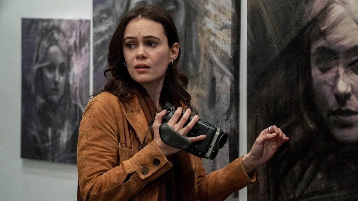 Dina Shihabi holds a video camera and appears frightened.