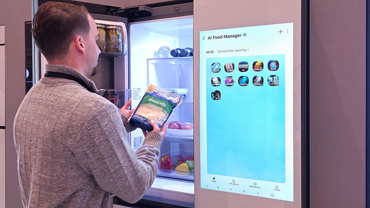 A person puts a package of shredded cheese into a refrigerator that has a large screen. This fridge has AI capabilities.