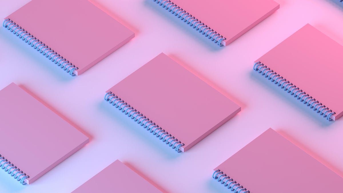 An image of pink notebooks lined up on a pink background (gettyimages-1420196304)