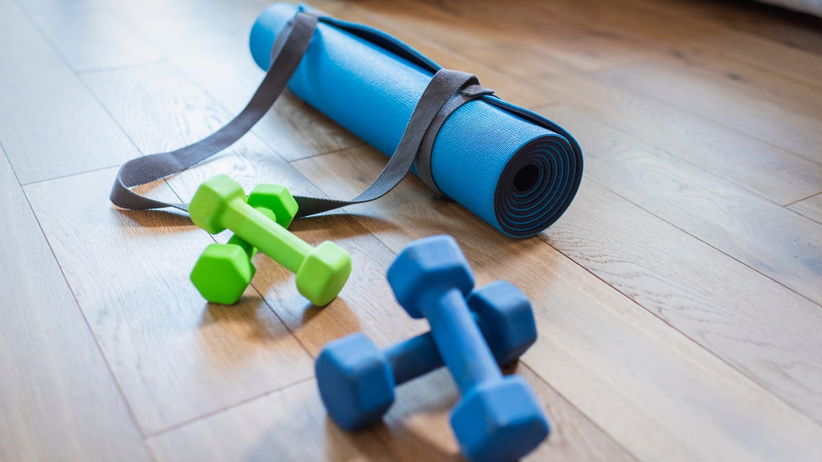Two sets of dumbbells and a yoga mat with a carry strap.