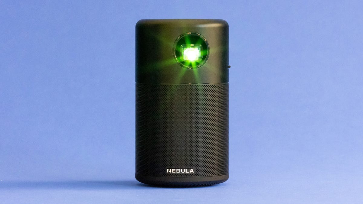 The Anker Nebula Capsule projector sits on a delicate blue background.