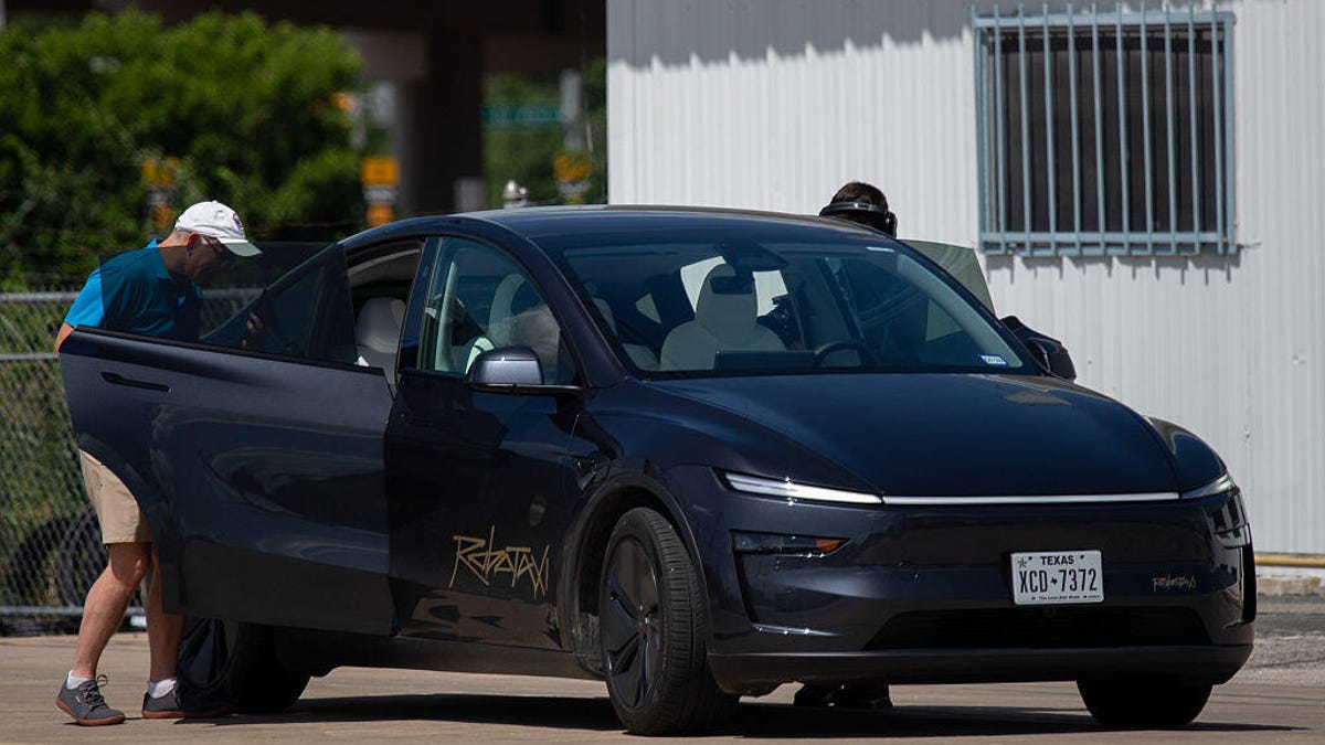 Two passengers get into a Tesla robotaxi