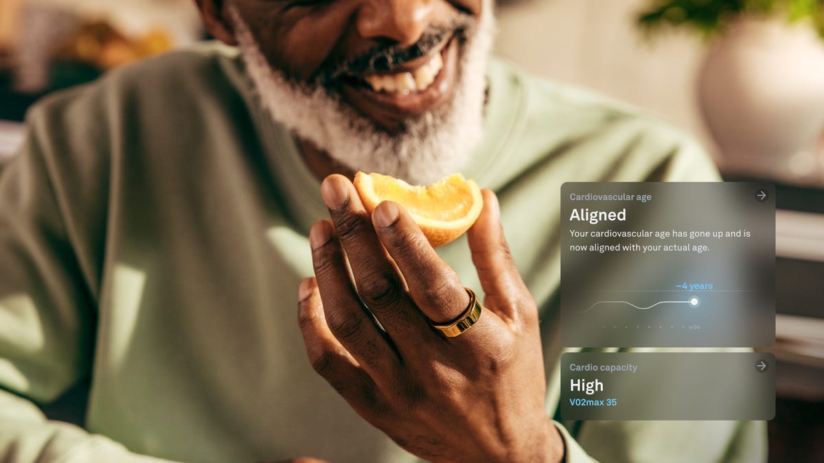 A man eating an orange while wearing an Oura ring