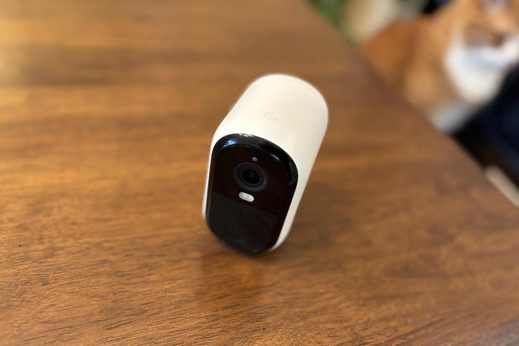 An Arlo Essential cam on a wooden table.