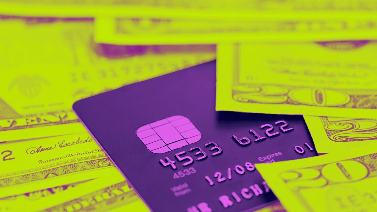 Purple credit card surrounded by cash