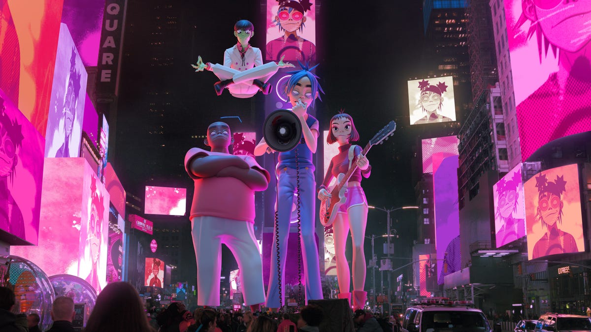 Gorillaz performers as cartoons standing in front of New York City's Times Square.