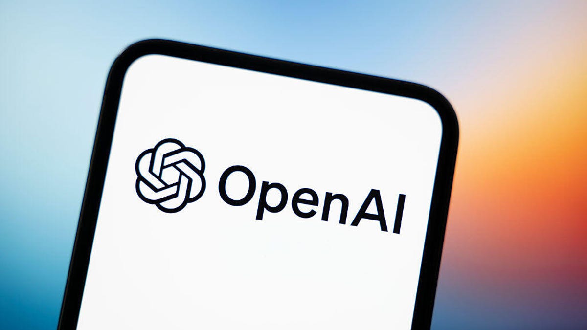 This photograph shows a smartphone screen displaying the logo of OpenAI.