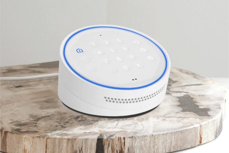 An ADT keypad on a indoor wood stump table.