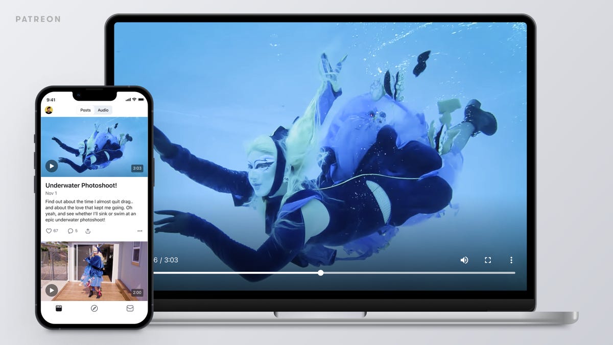 A laptop and smartphone screen showing a video of a costumed diver.