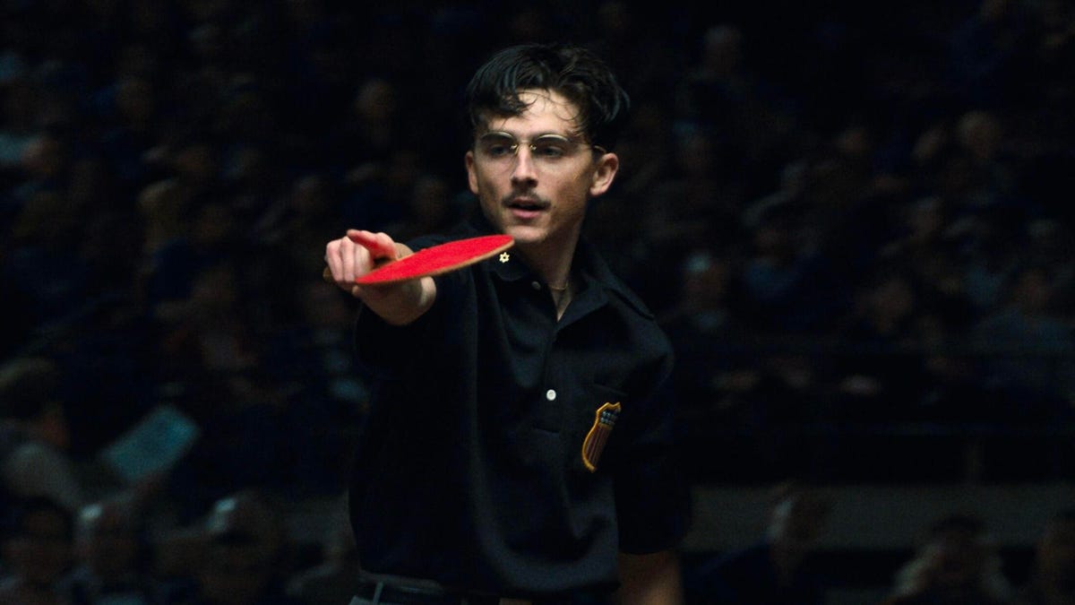 Timothée Chalamet holds a table tennis racket in a still from Marty Supreme.