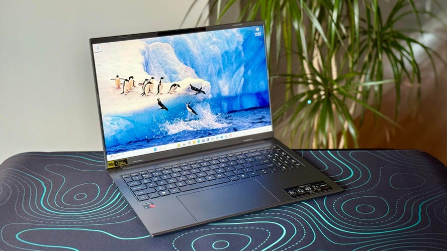 Acer Aspire 16 AI laptop at an angle on a desk mat with green swirls