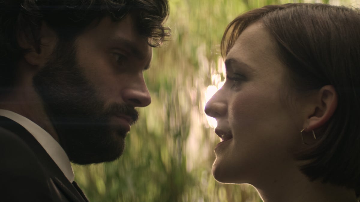 Close up of Joe and Kate looking at each other in a park