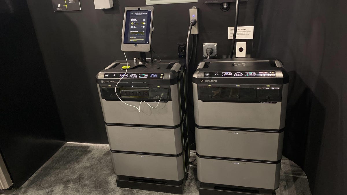 Two large stacks of batteries against a wall.