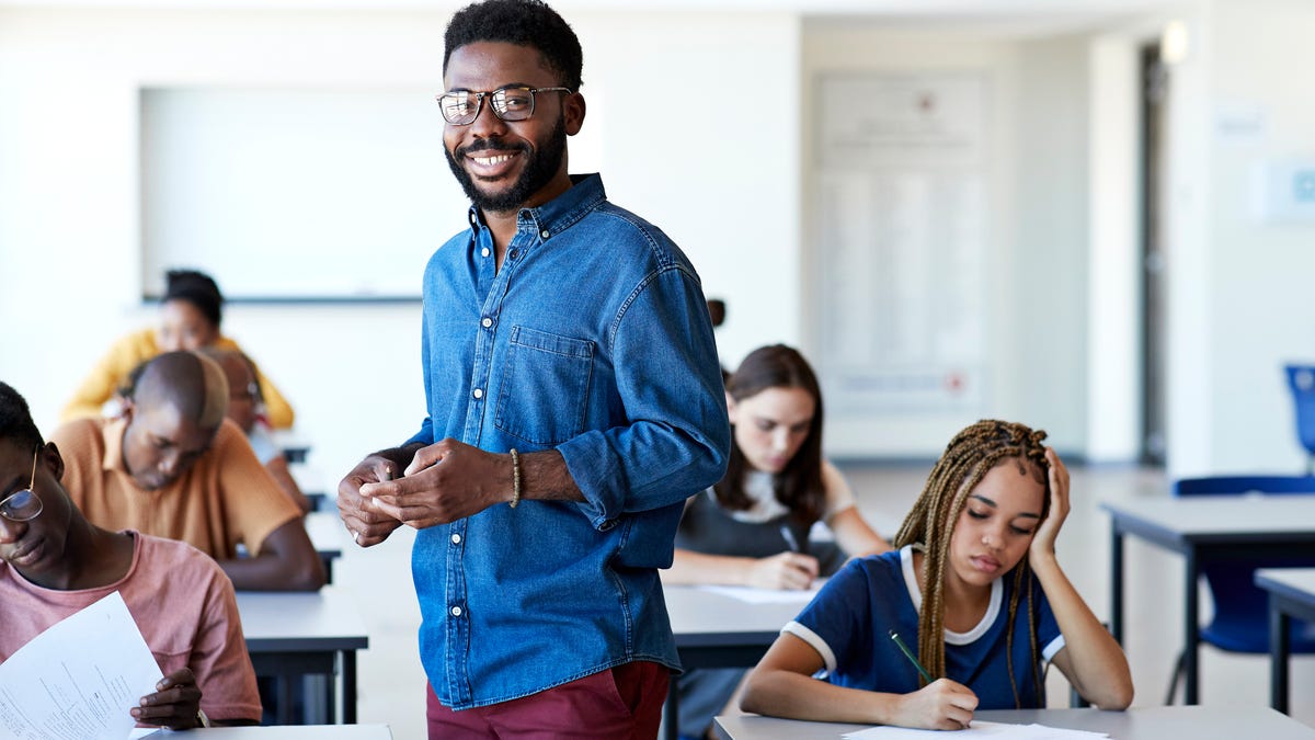 Teacher smiling in a classroom full of kids