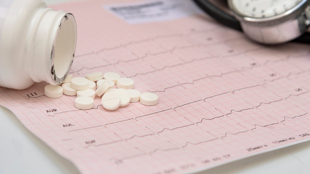 A bottle of pills spills on a light pink calendar