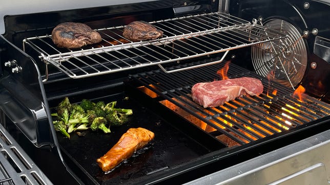 ninja grill cooking steak, slamon, broccoli and mushrooms on different sections