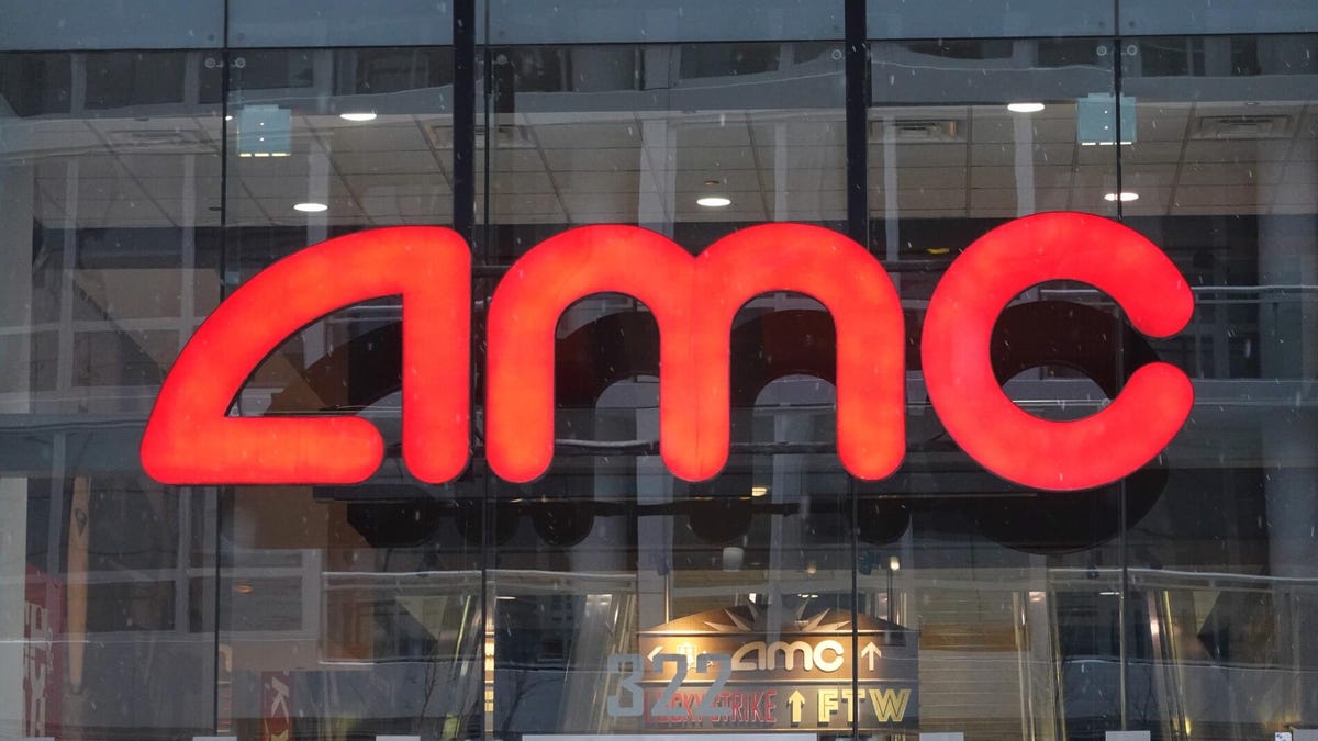 Red AMC logo perched on glass window of theater