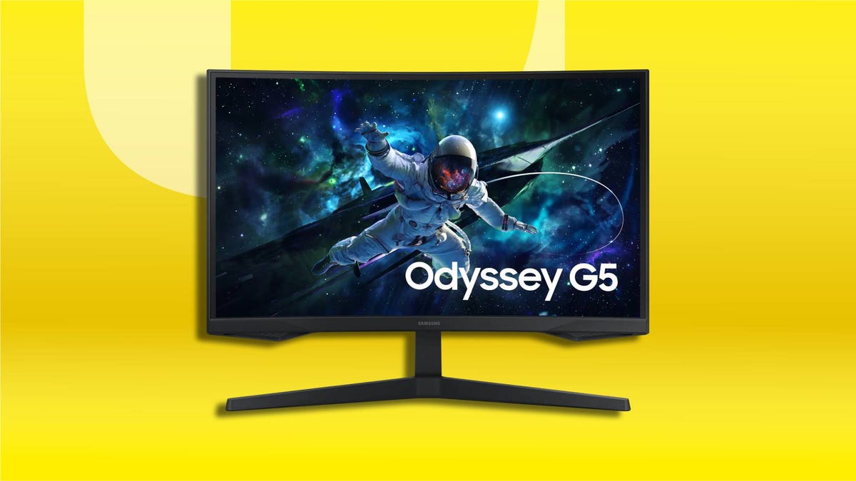 A curved widescreen gaming monitor displaying a vivid space scene with an astronaut floating through a colorful galaxy, set on CNET background.