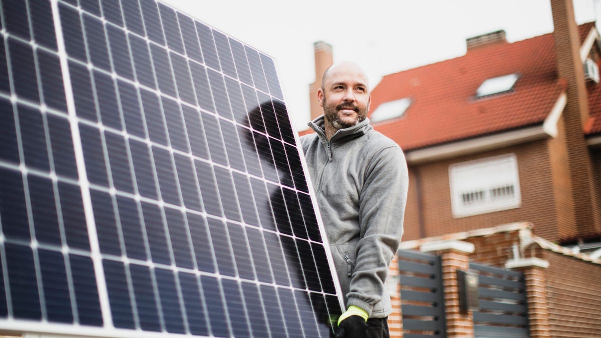 man holding solar panel