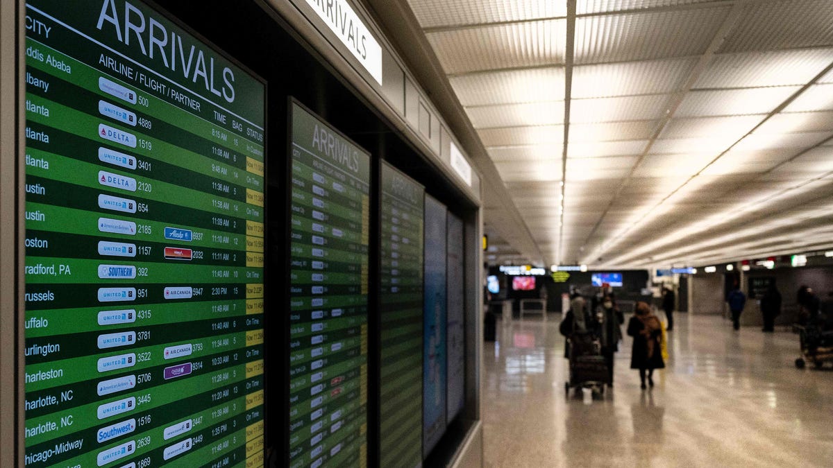 Travelers exit the International Arrivals area at Dulles International Airport
