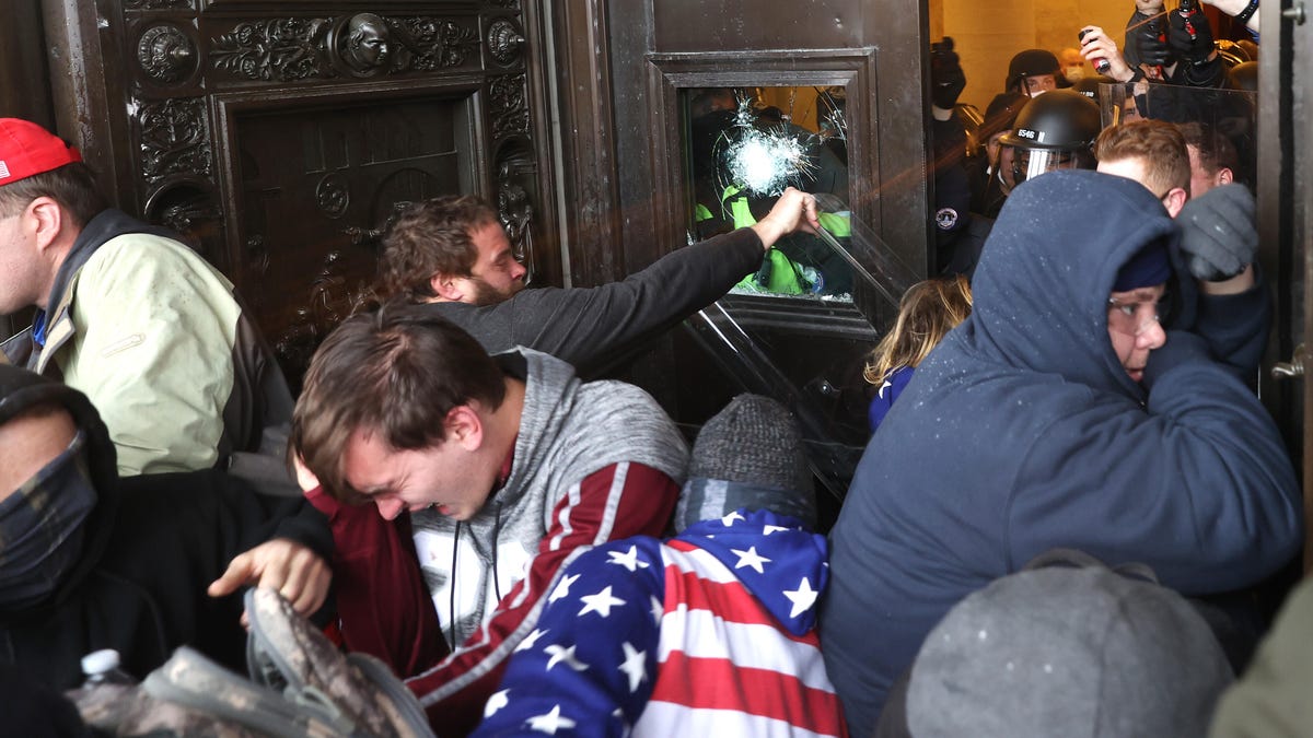 Trump supporters converge on a doorway into the US Capitol