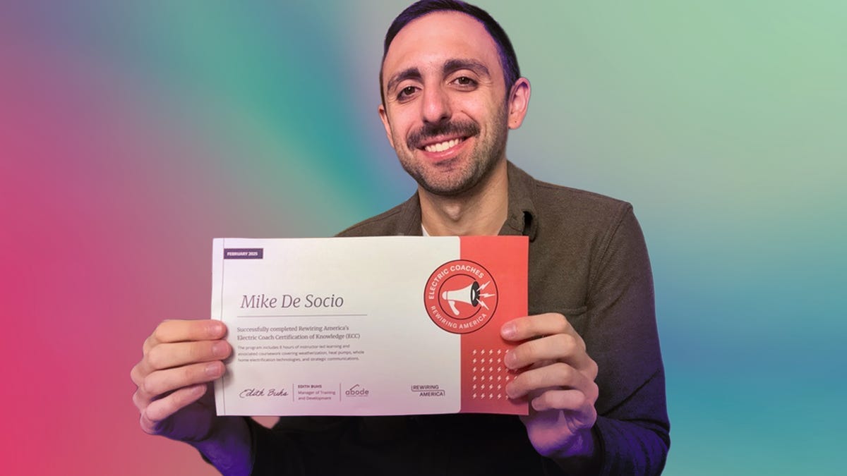 Mike is holding up his certificate of electric coach