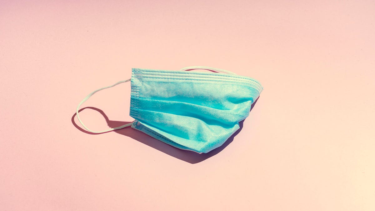 A blue mask against a peach background