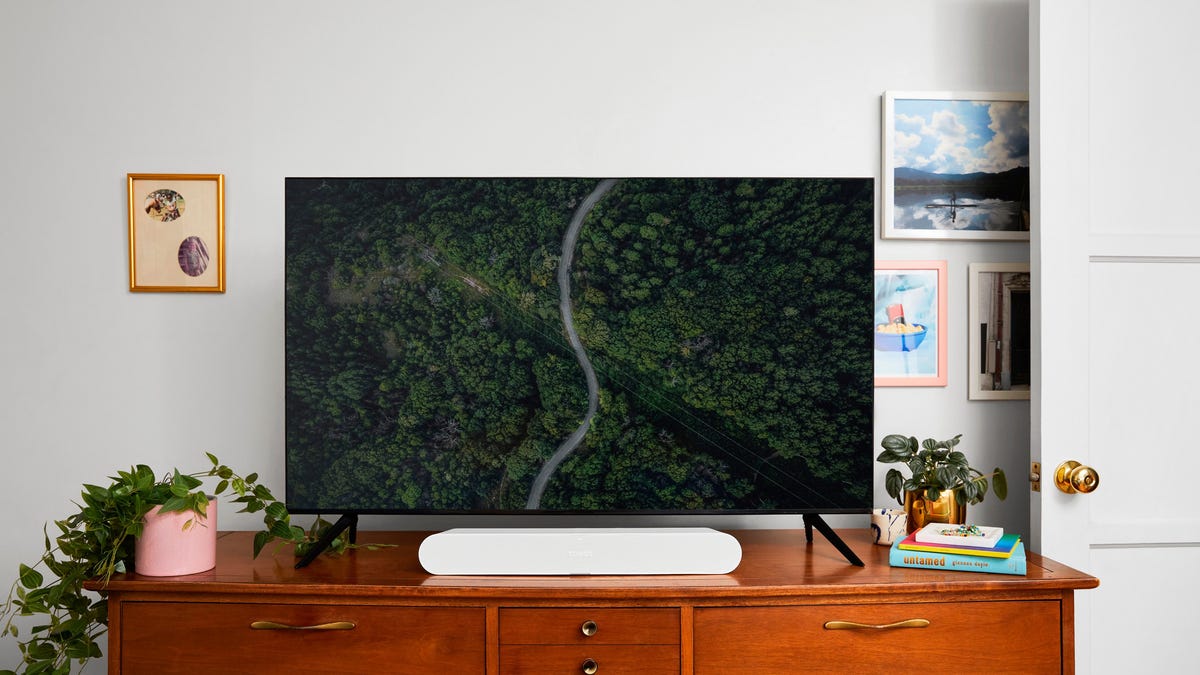 A soundbar in front of a TV on a dresser