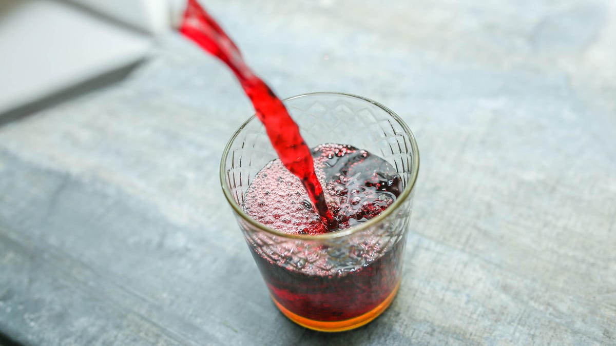 Red sparkling liquid being poured into a glass.