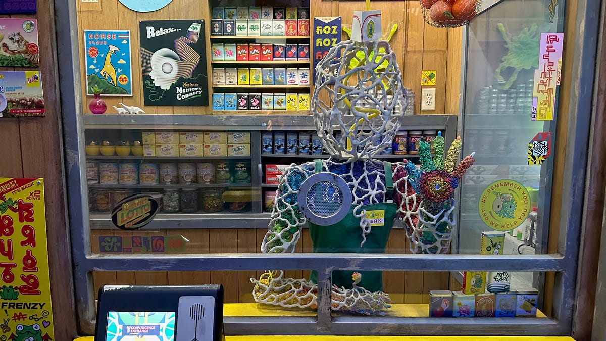 An art sculpture of a being inside a magic convenience shop booth, at Meow Wolf's Convergence Station