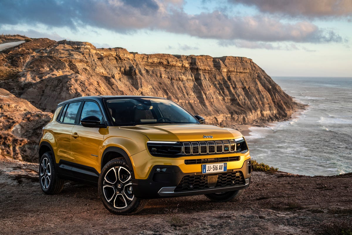 Front 3/4 view of the 2023 Jeep Avenger EV on a cliff overlooking the ocean