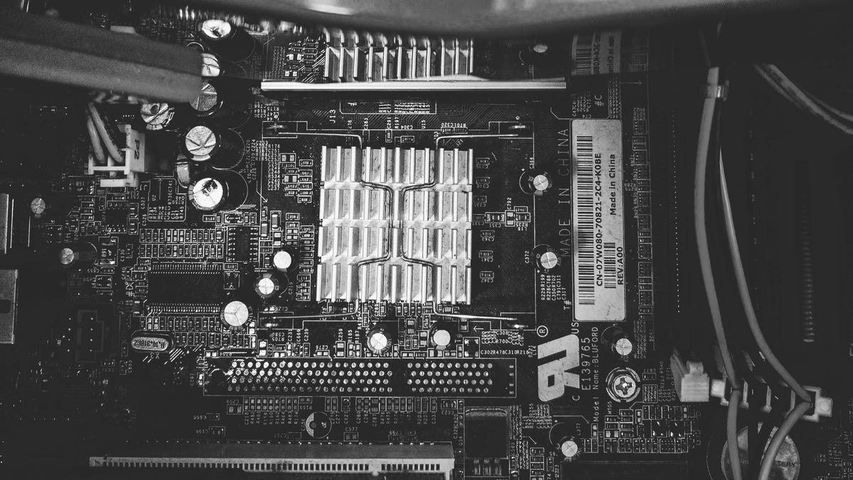 An old computer lies cracked open on a table.