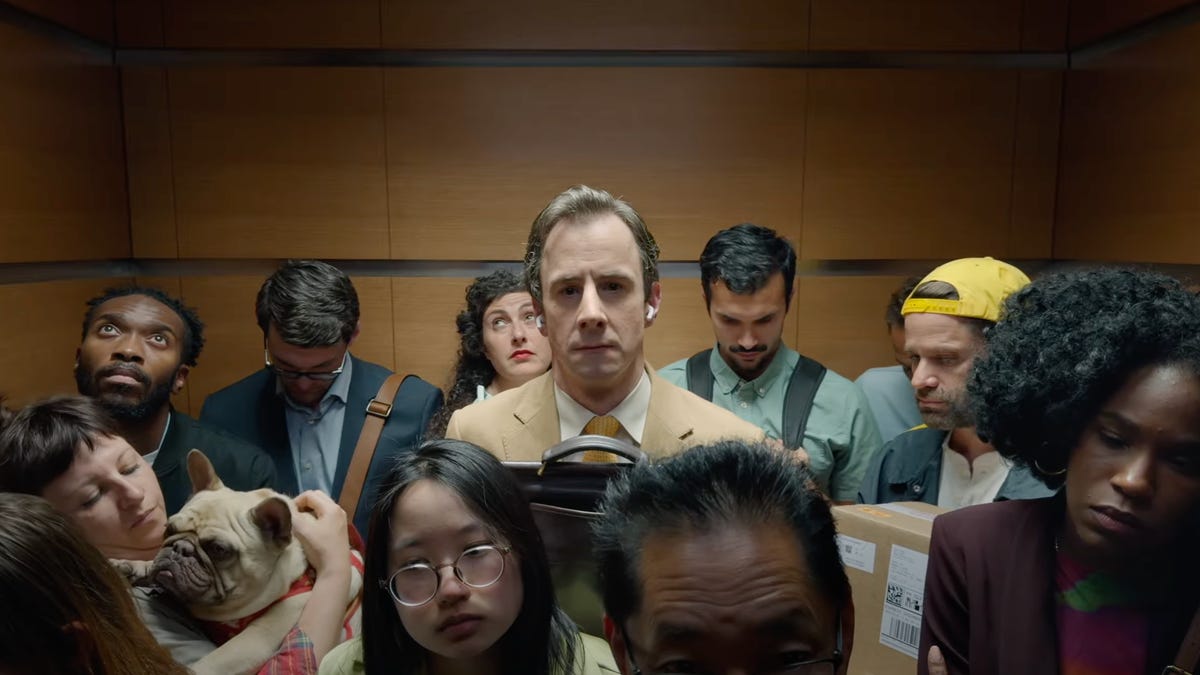 man standing in crowded elevators