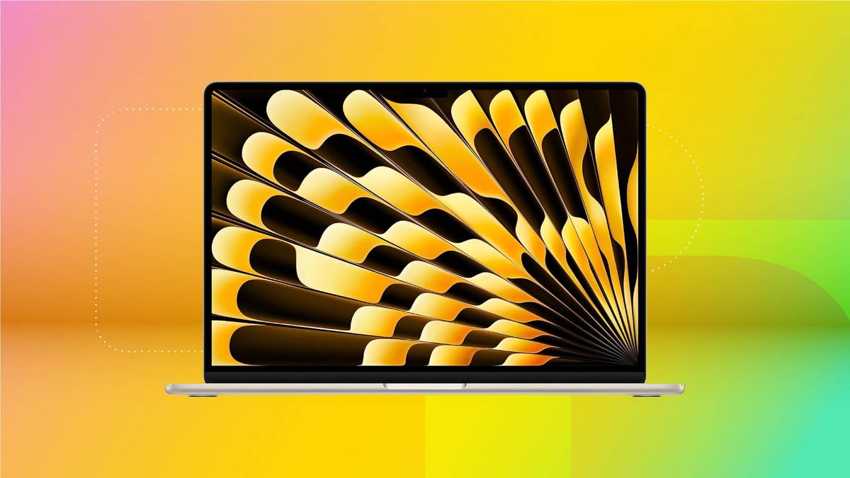 An open silver MacBook against a yellow gradient CNET background.