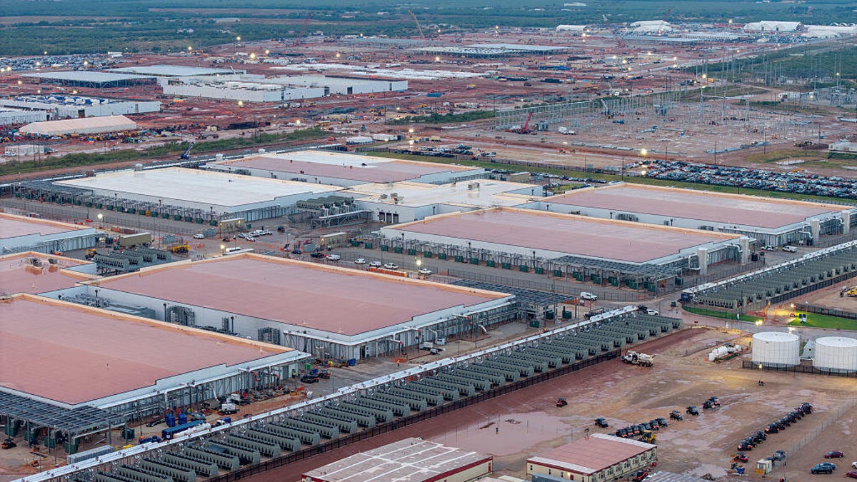 Large warehouse-looking data center buildings are seen from the air.